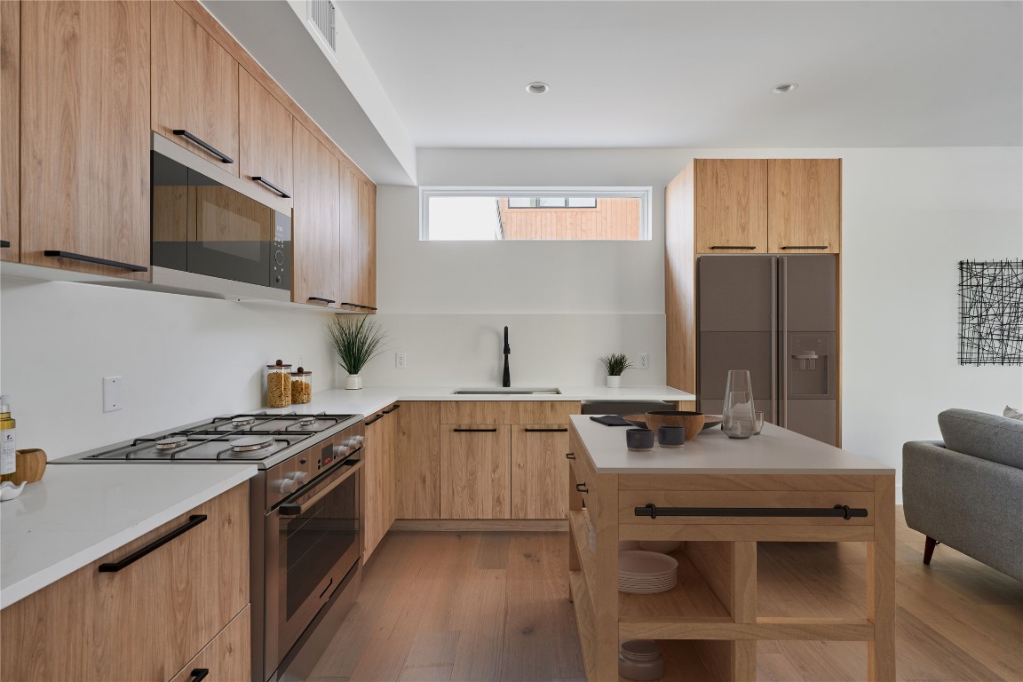 a kitchen with stainless steel appliances a sink stove and cabinets