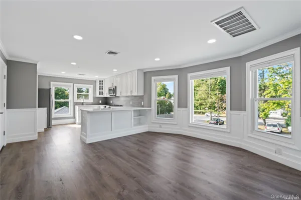 a large kitchen with stainless steel appliances granite countertop a large cabinets a sink and wooden floor