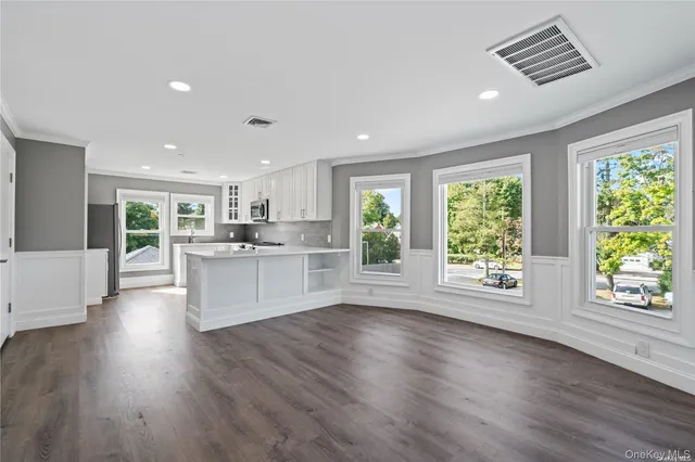 a large kitchen with stainless steel appliances granite countertop a large cabinets a sink and wooden floor