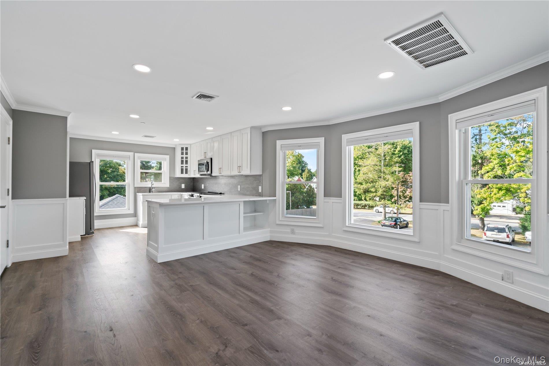 a large kitchen with stainless steel appliances granite countertop a large cabinets a sink and wooden floor