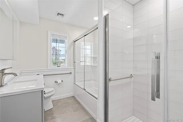 a bathroom with a double vanity sink toilet and shower