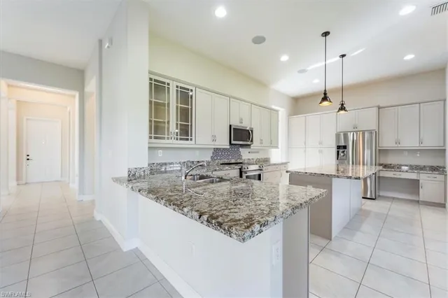 a kitchen with kitchen island granite countertop a sink cabinets and window