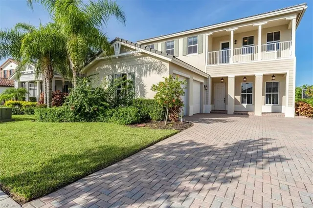 a front view of a house with a yard and potted plants