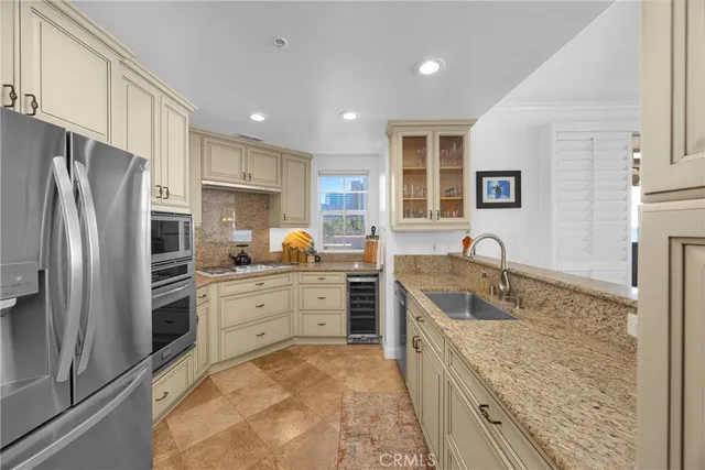 a kitchen with granite countertop a sink stainless steel appliances and counter space
