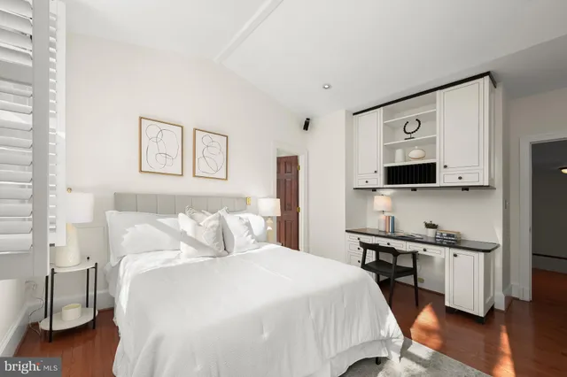 a bedroom with a bed and a flat tv screen on the dresser