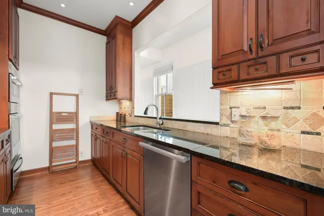 a kitchen with granite countertop a sink and cabinets