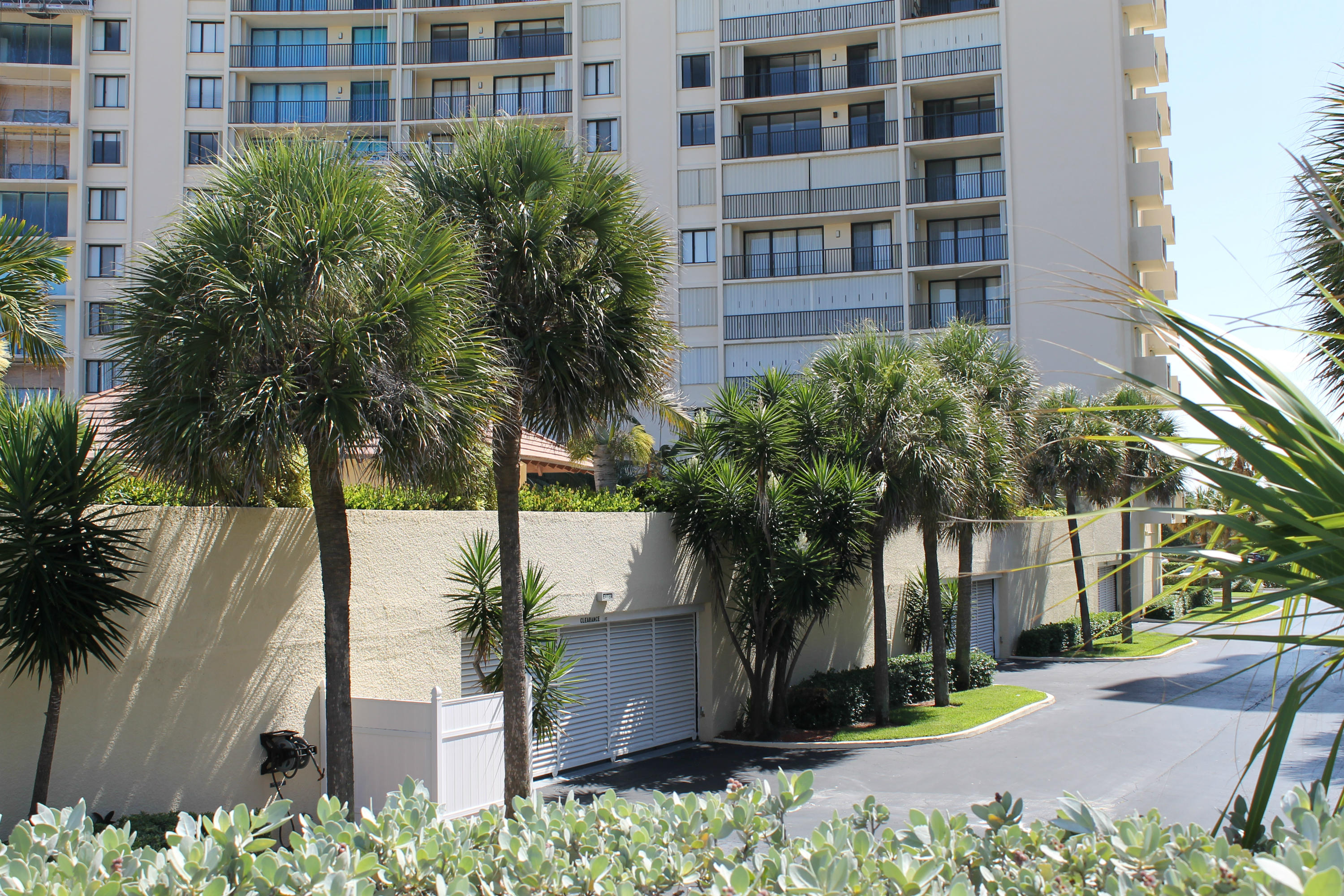 300 Ocean Trail Way, Unit 1010 Jupiter, FL 33477 - Photo 24 of 25 a front view of multi story residential apartment building with a yard and potted plants