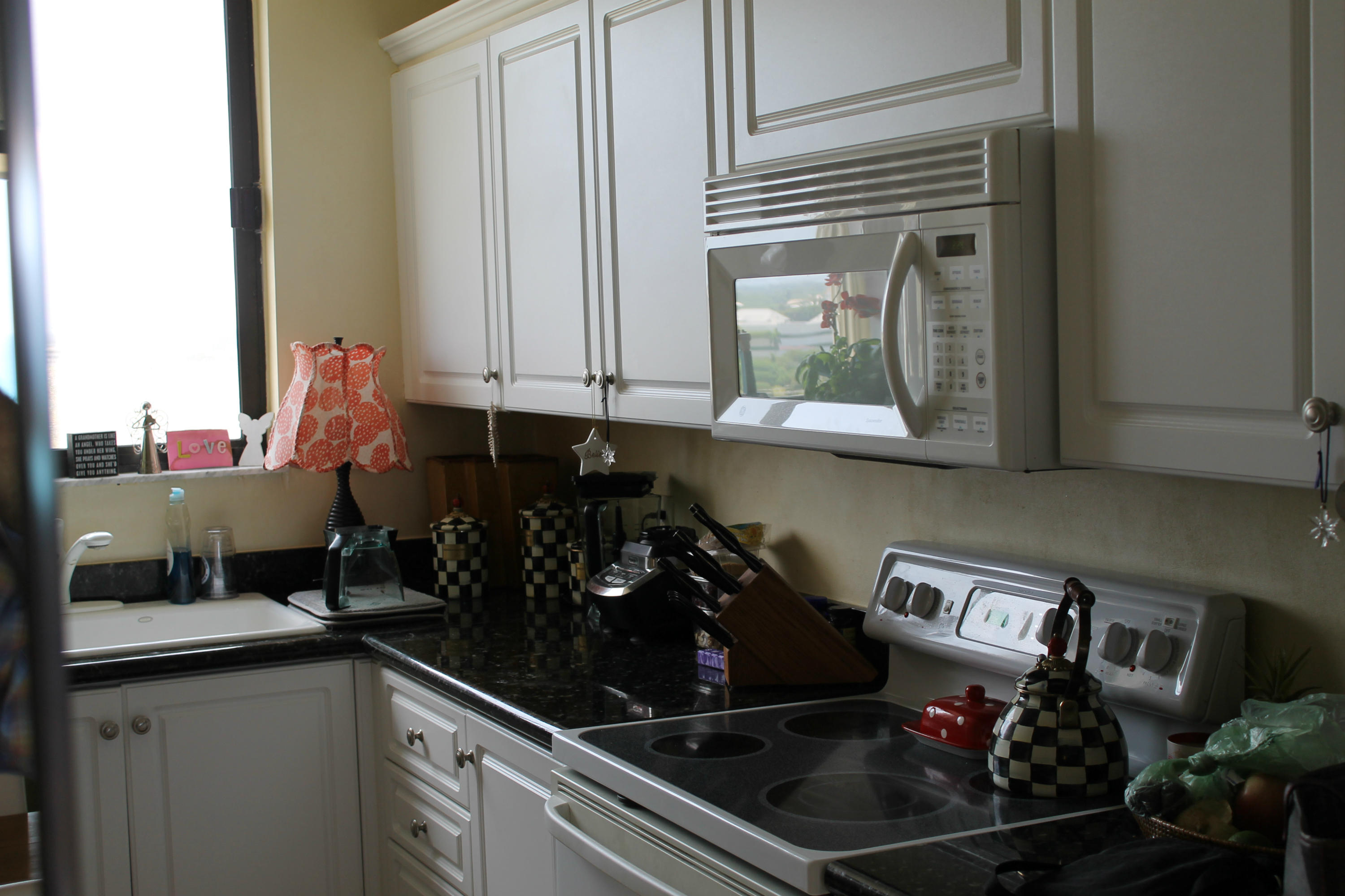 300 Ocean Trail Way, Unit 1010 Jupiter, FL 33477 - Photo 7 of 25 a kitchen with a stove a microwave and cabinets
