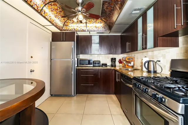 a kitchen with stainless steel appliances granite countertop a stove a refrigerator and a sink