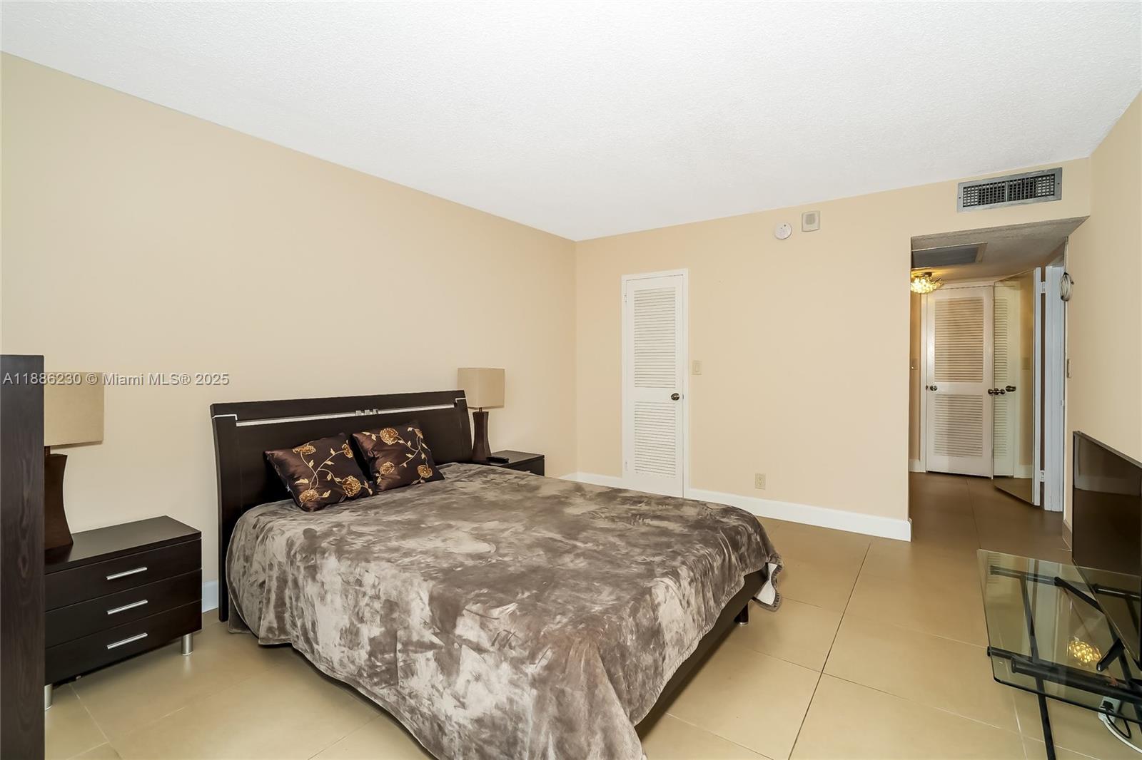 2030 South Ocean Drive, Unit 1118 Hallandale Beach, FL 33009 - Photo 21 of 58 a bedroom with a bed and a tv on the dresser