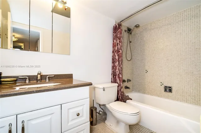a bathroom with a granite countertop sink a toilet and a mirror