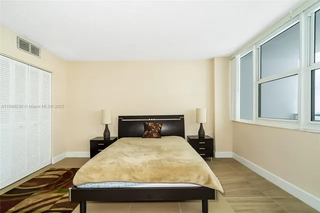 a large bed sitting in a bedroom next to a window