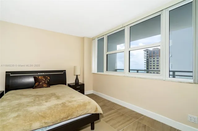 a bedroom with a bed and a view of living room