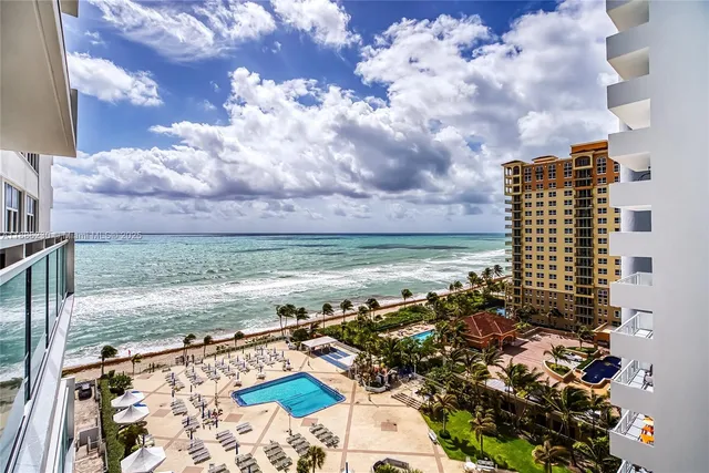 a living room with large window chandelier and dining table