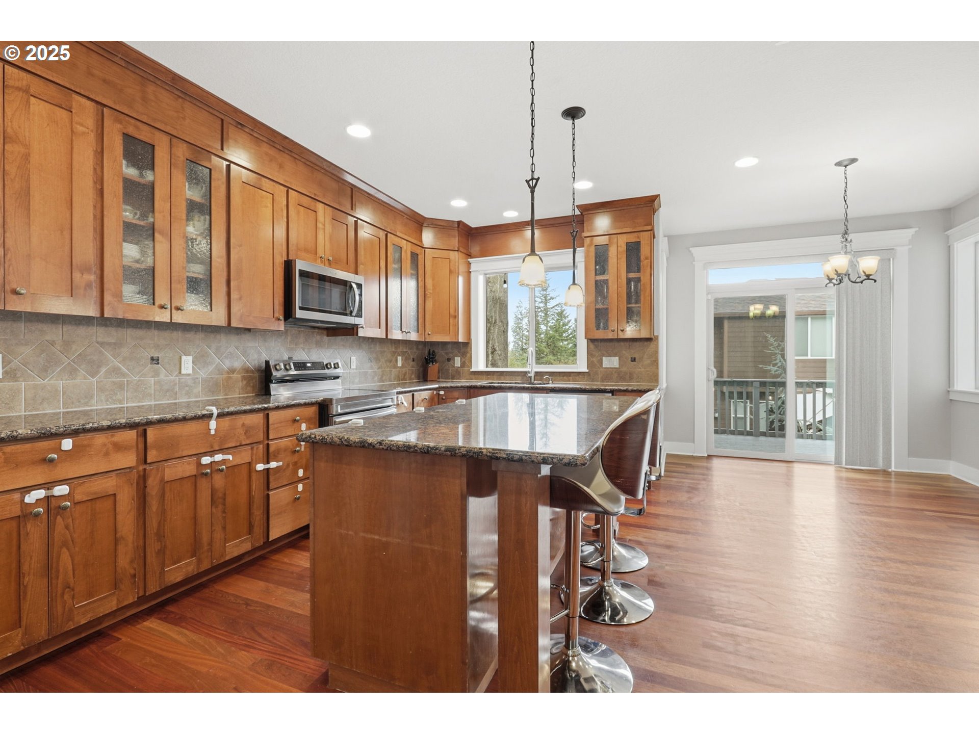 937 Southwest Florence Court Gresham, OR 97080 - Photo 7 of 47 a kitchen with stainless steel appliances granite countertop a refrigerator a sink dishwasher a stove and a dining table with wooden floor
