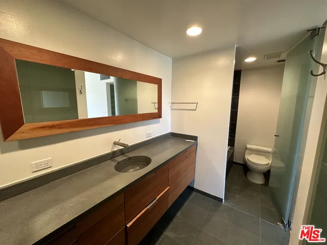 a bathroom with a sink a toilet a mirror and window