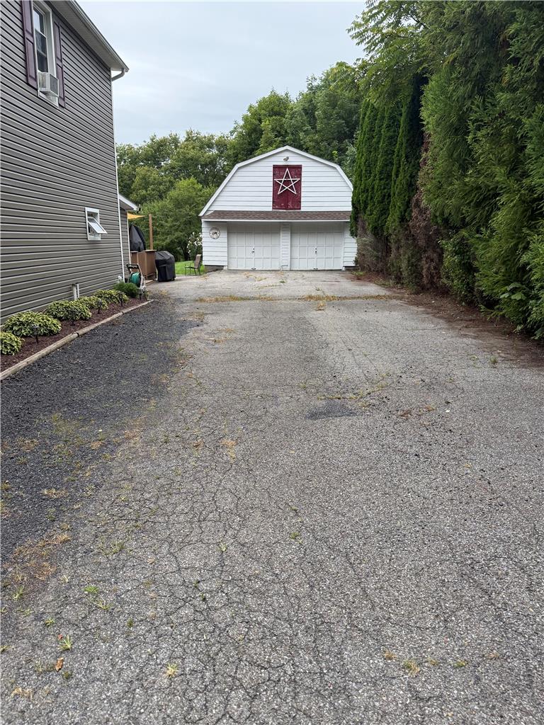 1114 Fox Gap Road Bangor, PA 18013 - Photo 51 of 63 An expansive asphalt driveway leads to a detached garage flanked by mature privacy landscaping.