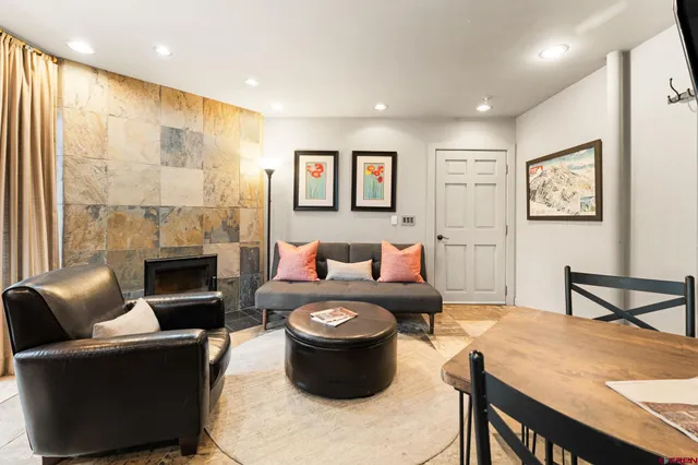 a living room with furniture a fireplace and a large window