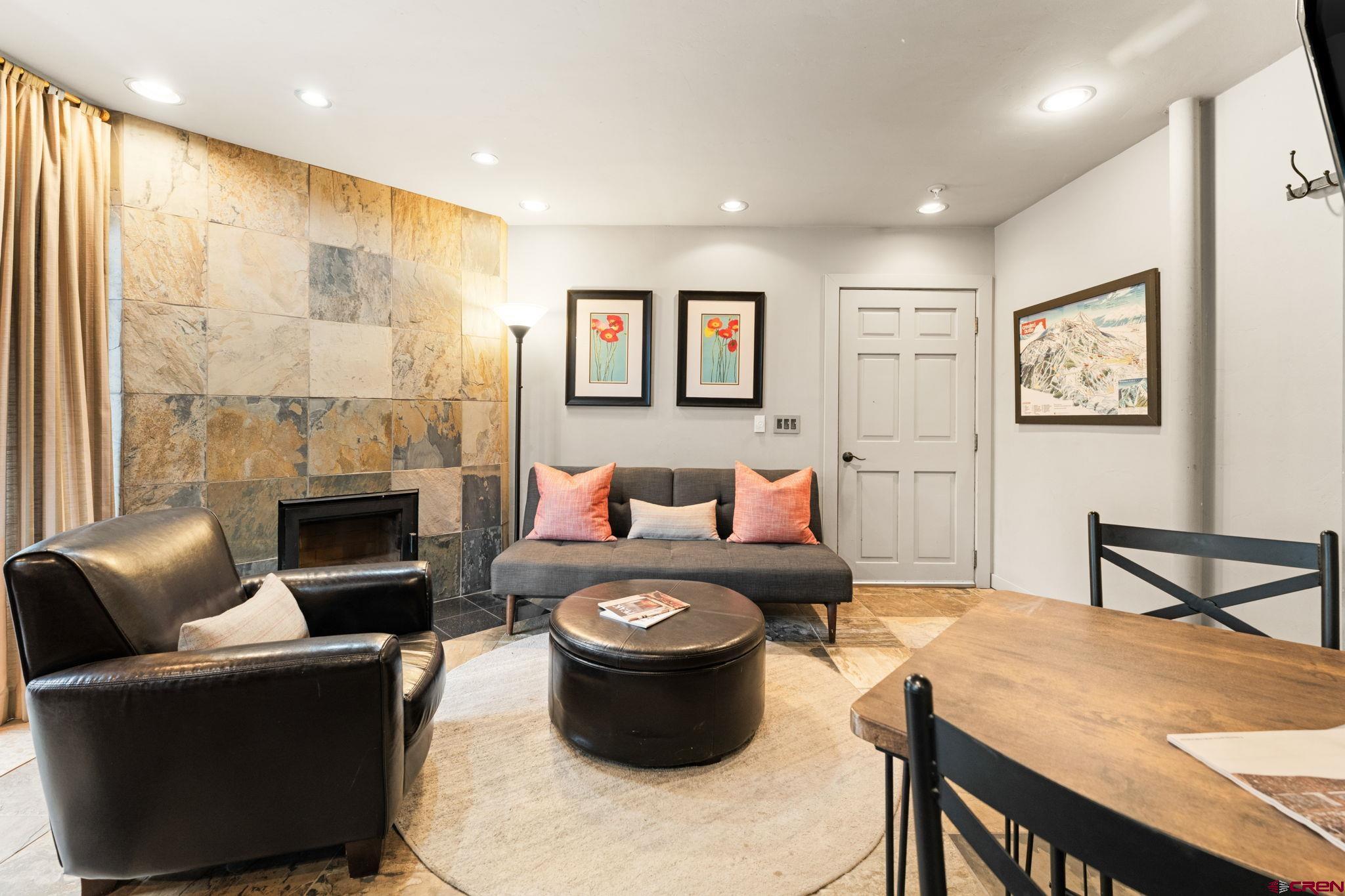 11 Emmons Road, Unit 322 Crested Butte, CO 81225 - Photo 3 of 21 a living room with furniture a fireplace and a large window