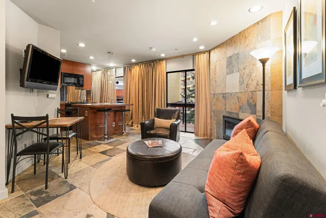 a living room with furniture a flat screen tv and a large window
