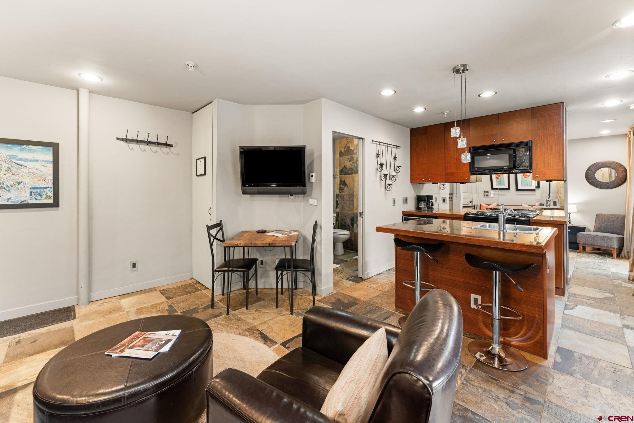 11 Emmons Road, Unit 322 Crested Butte, CO 81225 - Photo 6 of 21 a living room with furniture a flat screen tv and kitchen view