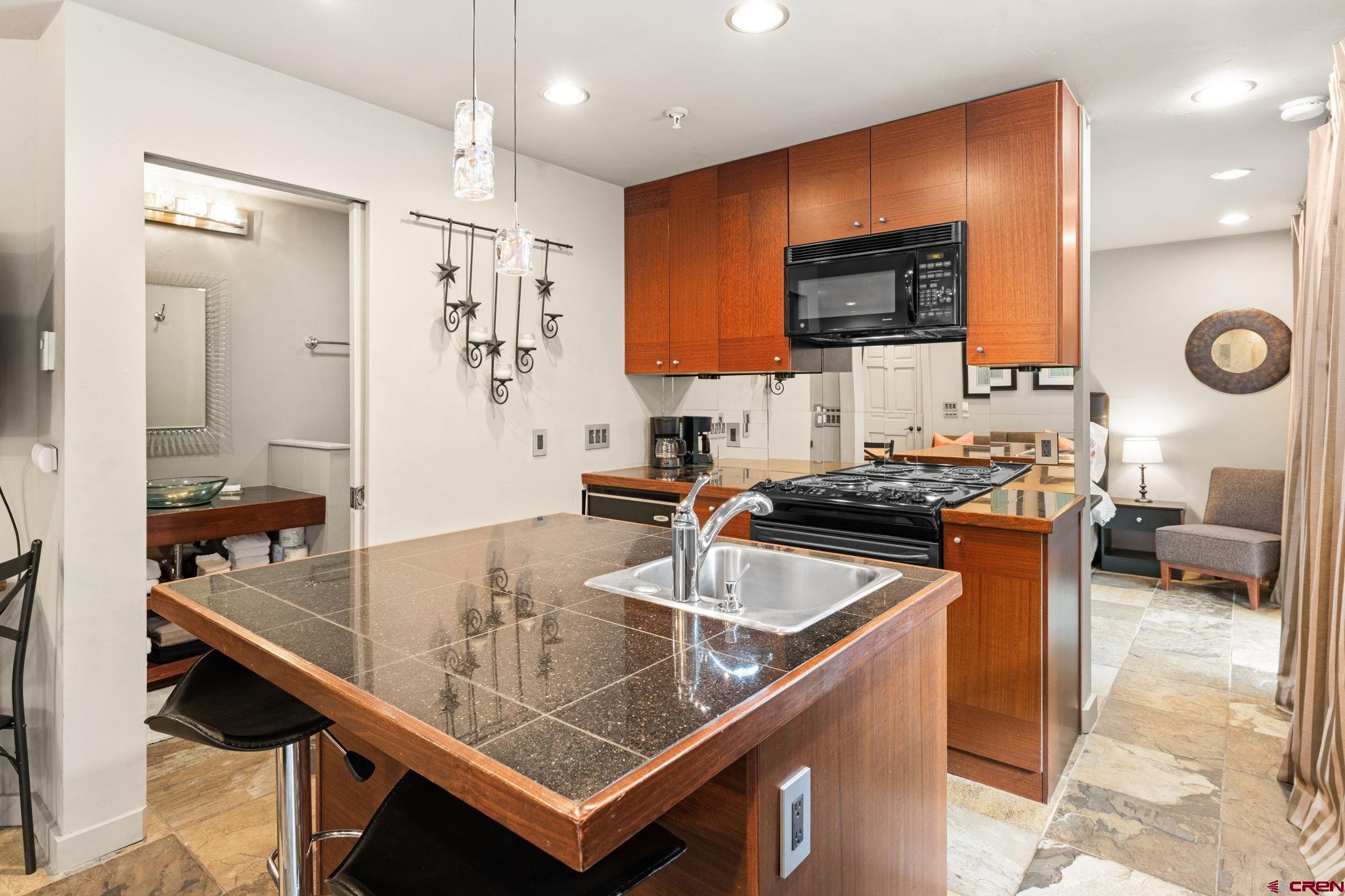 11 Emmons Road, Unit 322 Crested Butte, CO 81225 - Photo 7 of 21 a kitchen with stainless steel appliances granite countertop a sink a stove counter space and cabinets
