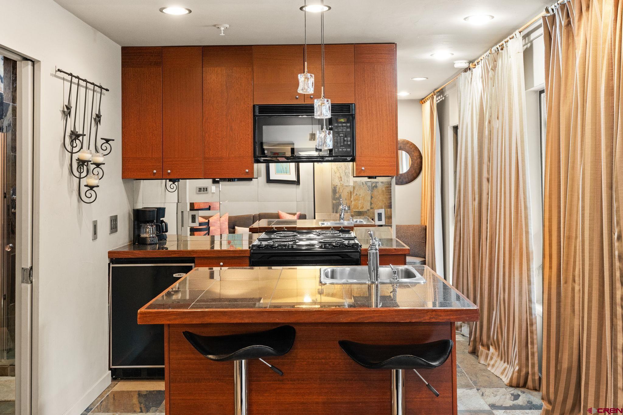 11 Emmons Road, Unit 322 Crested Butte, CO 81225 - Photo 8 of 21 a room with a table chairs and refrigerator