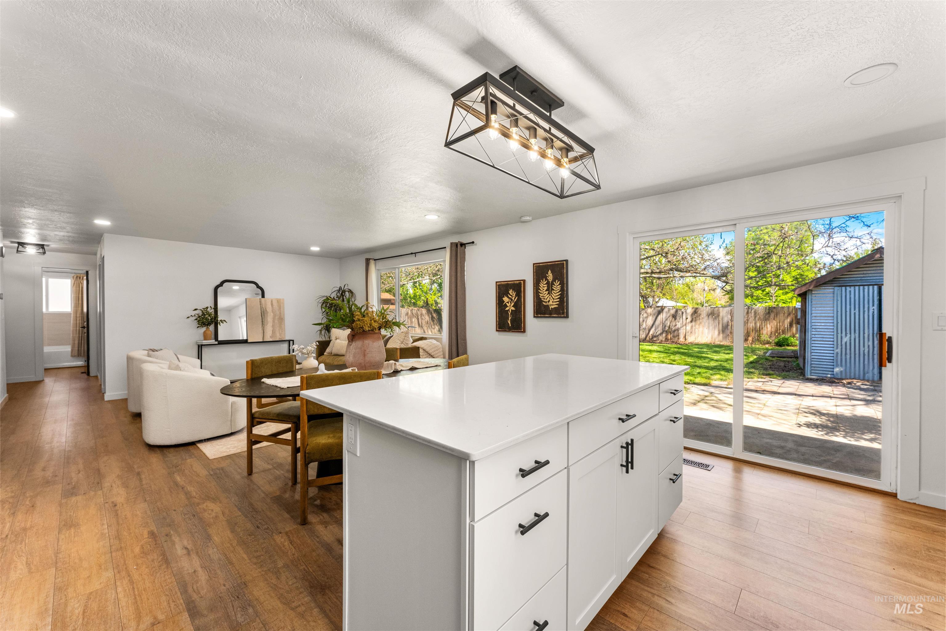 4700 Jennifer Street Boise, ID 83704 - Photo 12 of 39 Kitchen island with white cabinetry and dark hardware, wood-finish flooring, recessed lighting, and a sliding glass door