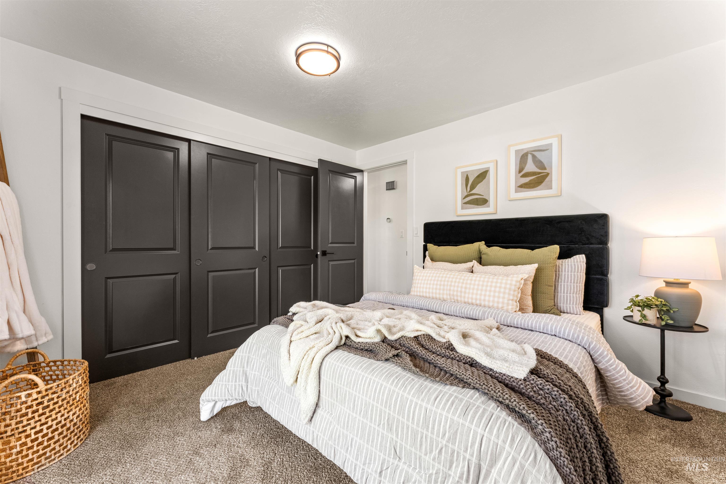 4700 Jennifer Street Boise, ID 83704 - Photo 20 of 39 Bedroom featuring dark panel closet doors, light neutral walls, and textured carpeting