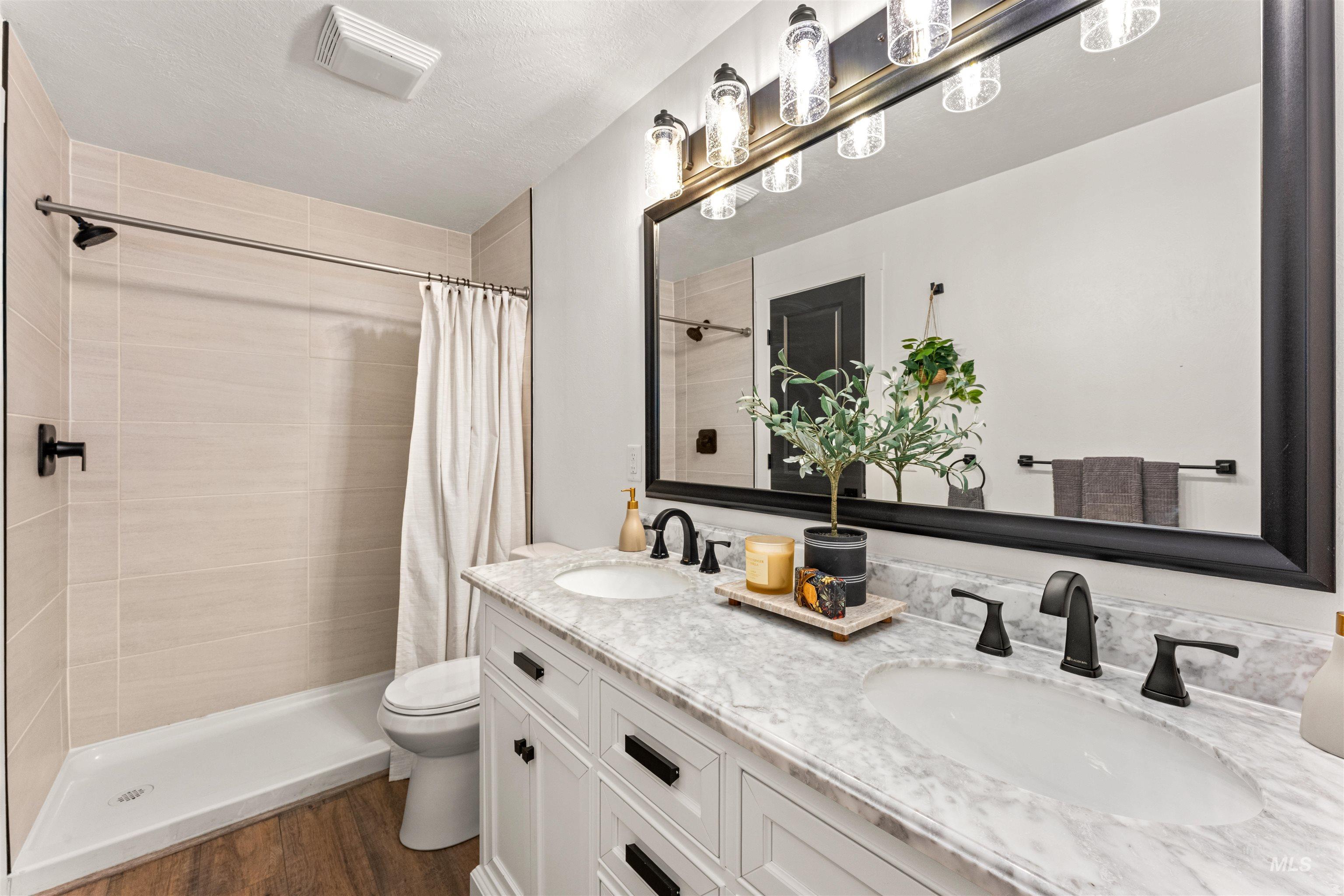 4700 Jennifer Street Boise, ID 83704 - Photo 22 of 39 Bathroom featuring a dual-sink vanity with a light-toned countertop, white cabinetry, and matte black fixtures