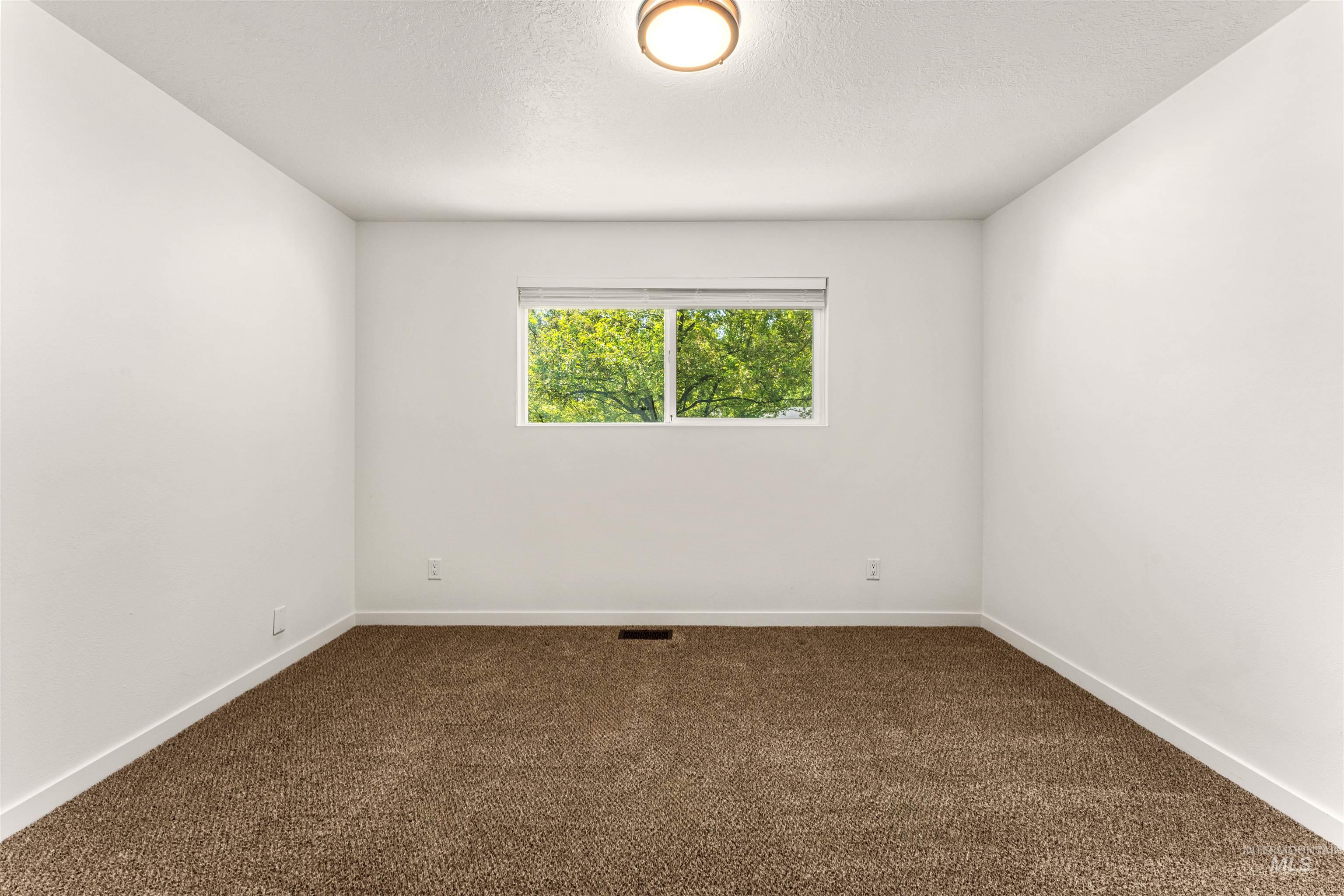 4700 Jennifer Street Boise, ID 83704 - Photo 24 of 39 Room featuring neutral white walls, brown carpeting, and a single window with a roller shade