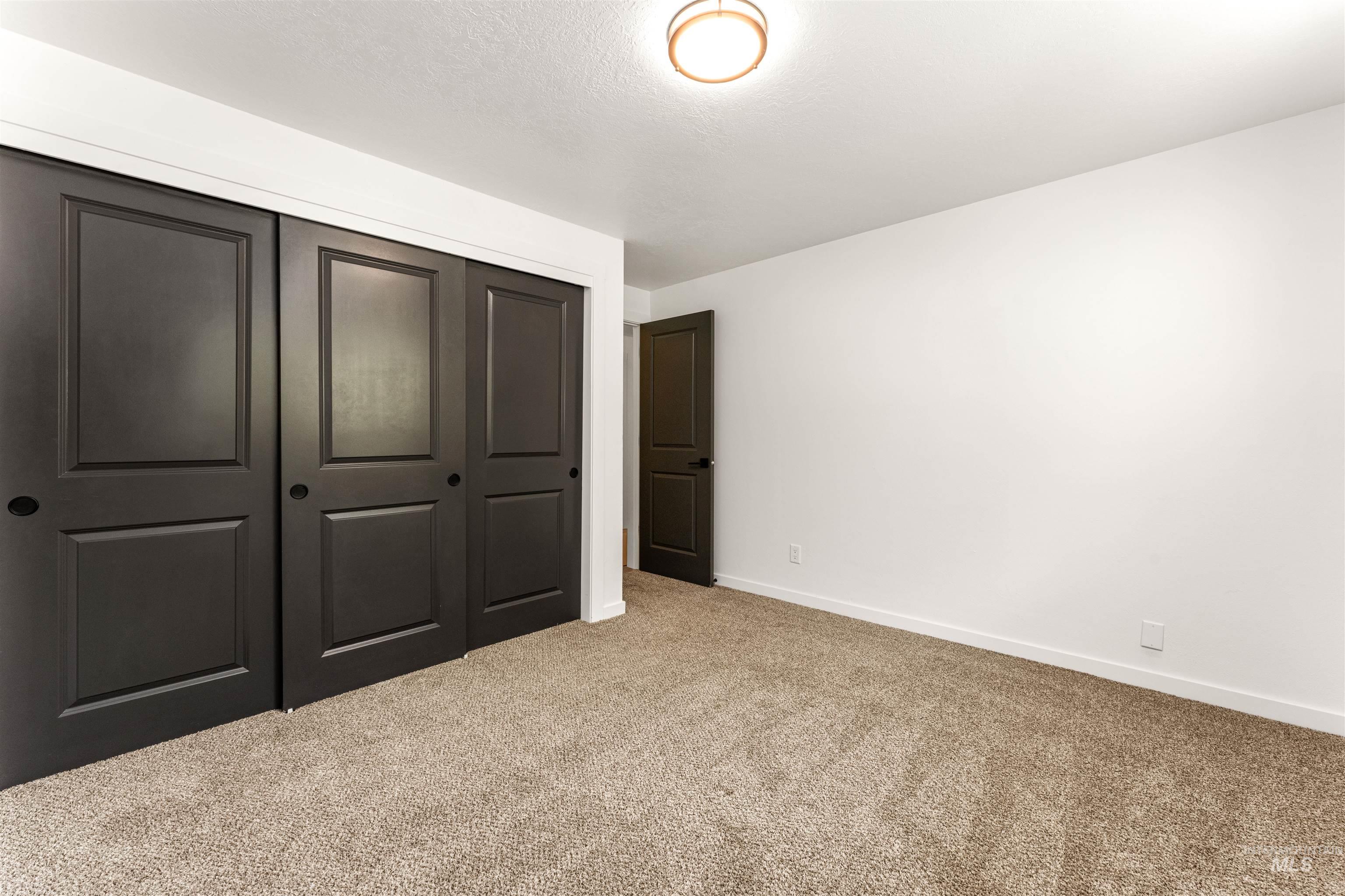 4700 Jennifer Street Boise, ID 83704 - Photo 25 of 39 Spacious room featuring neutral carpeting, white walls, and a modern ceiling light fixture
