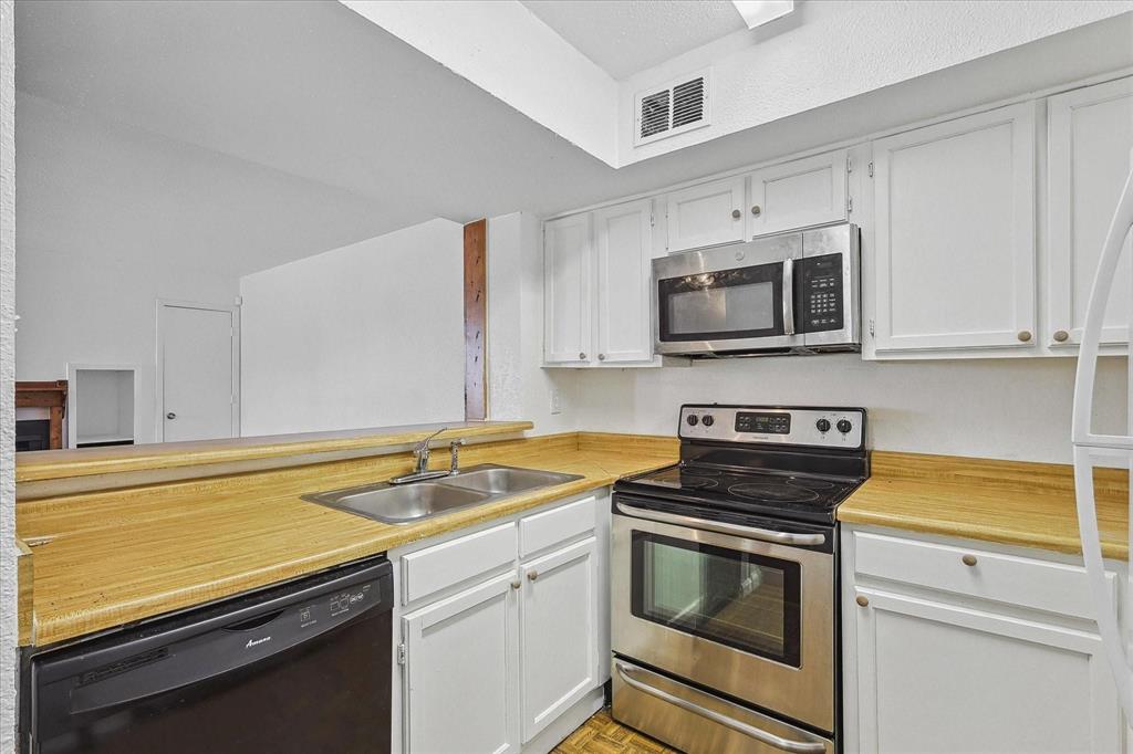 9821 Walnut Street, Unit 101 Dallas, TX 75243 - Photo 14 of 17 a kitchen with a sink stove and microwave