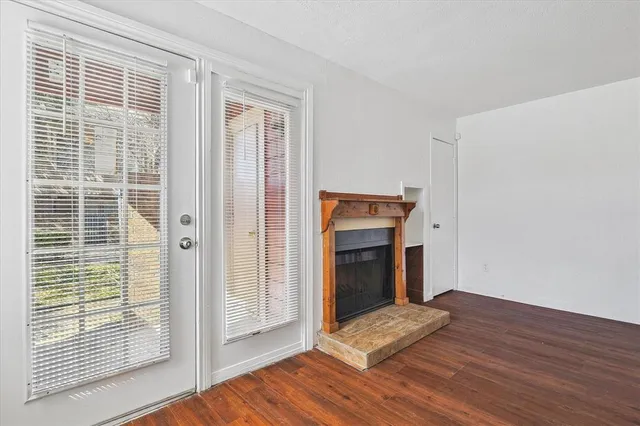 a view of empty room with wooden floor and fireplace