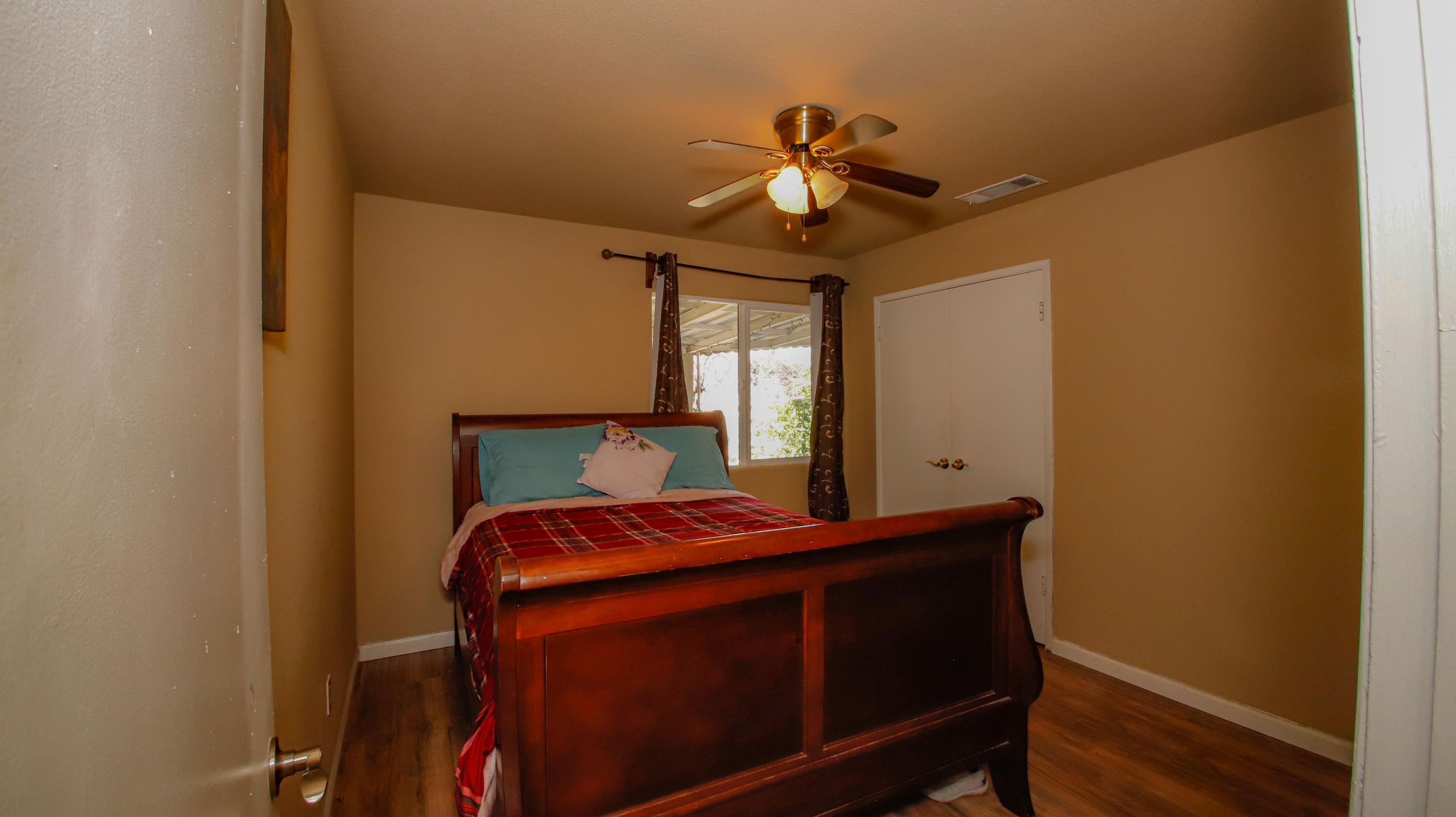 7441 Pacheco Road Redding, CA 96002 - Photo 9 of 19 a bedroom with a bed and wooden floor