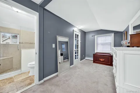 a bedroom with a bed and a view of living room