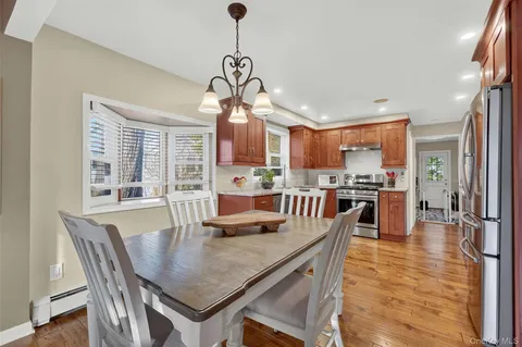 a view of a dining room and livingroom with furniture wooden floor a chandelier