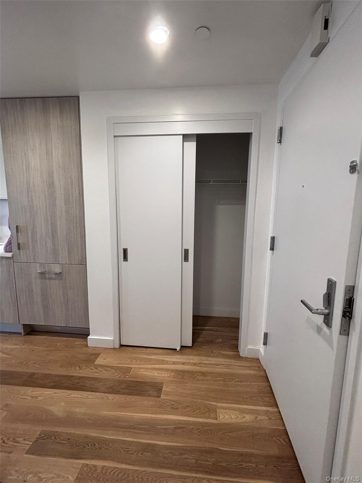 131-03 40 Road, Unit 15L Queens, NY 11354 - Photo 6 of 11 a view of a hallway with wooden floor and staircase