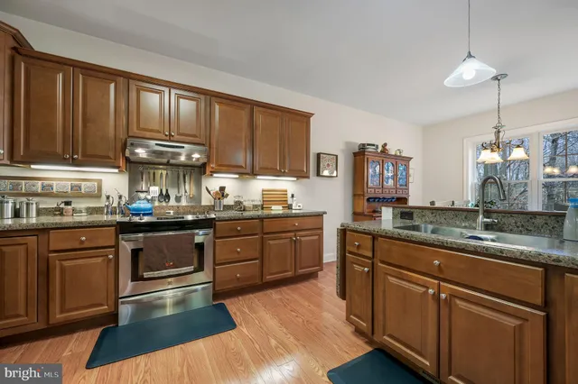 a kitchen with granite countertop wooden cabinets and white appliances