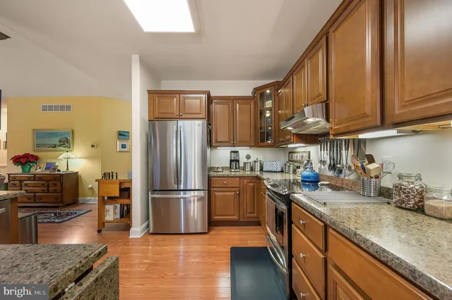 a kitchen with stainless steel appliances granite countertop a refrigerator a stove top oven a sink and dishwasher