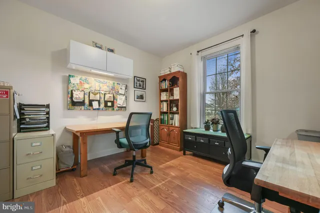 a view of a workspace with furniture and a window