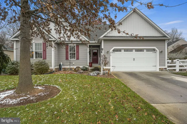 a view of a house with a big yard and large trees
