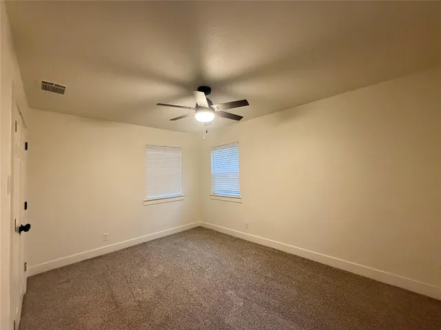 an empty room with a empty space and a ceiling fan