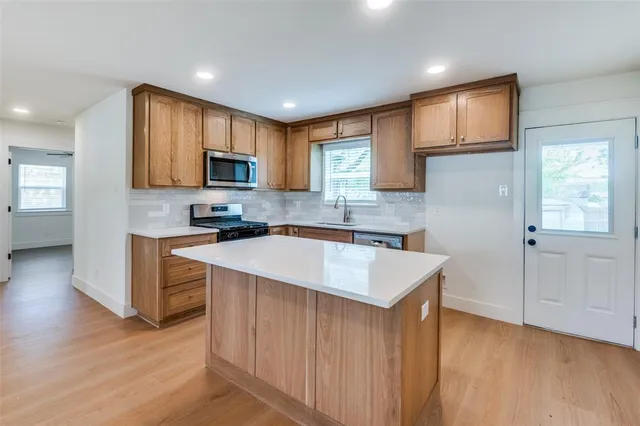 a kitchen with stainless steel appliances granite countertop a sink stove and refrigerator