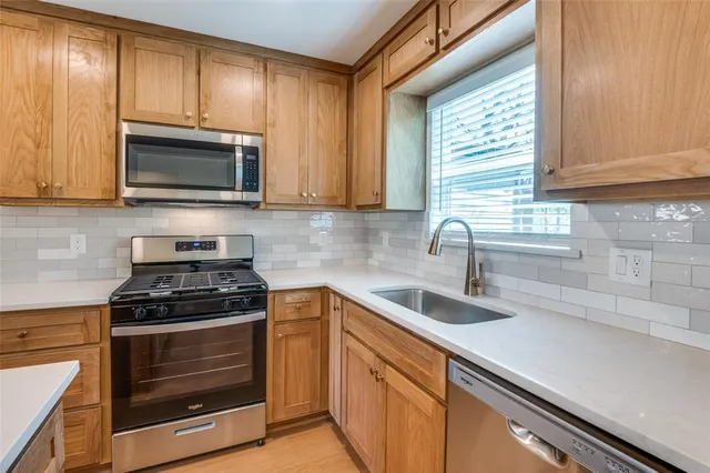 a kitchen with granite countertop a sink stove and microwave