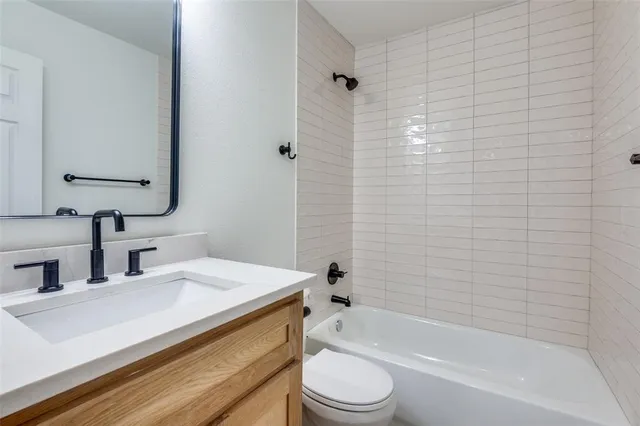 a bathroom with a bathtub shower sink vanity and toilet