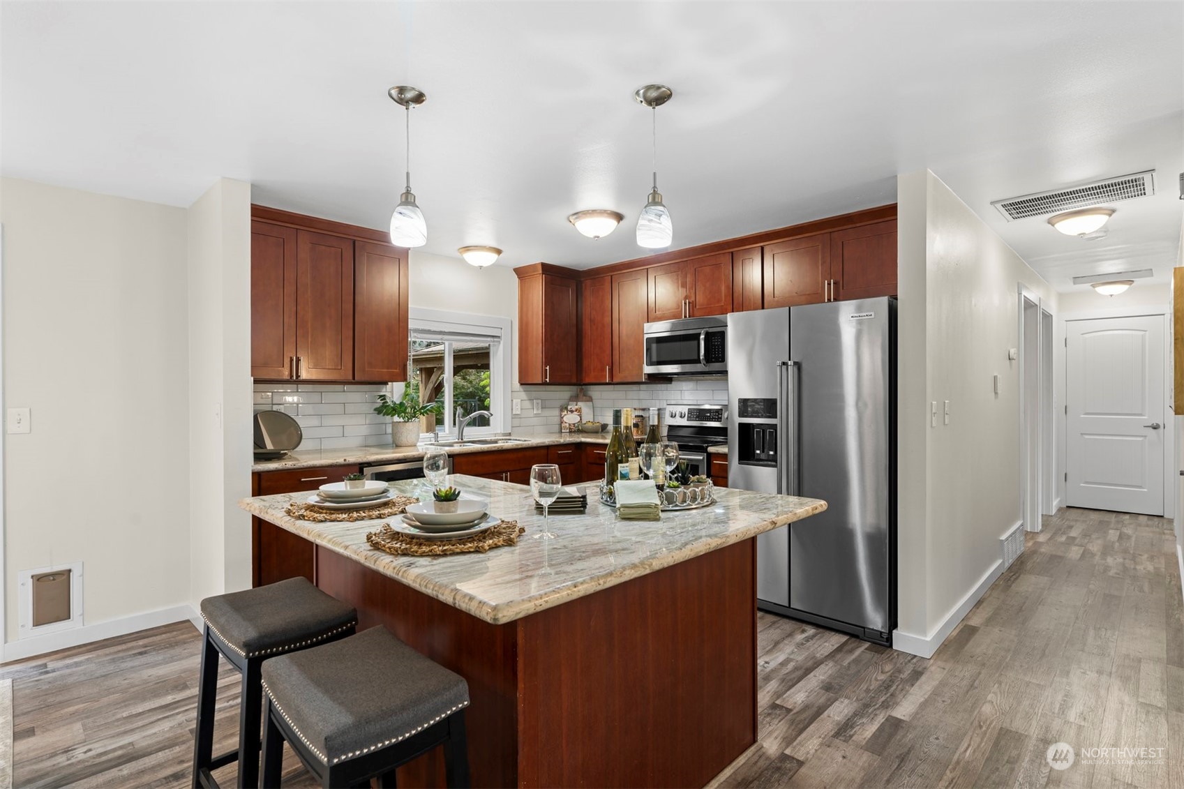 24301 7th Place West Bothell, WA 98021 - Photo 9 of 40 a kitchen with a refrigerator a stove a sink and a dining table with wooden floor