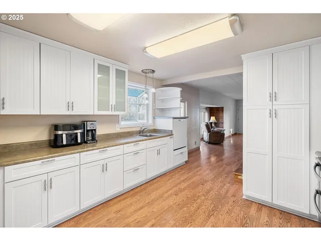 a kitchen with a refrigerator a stove top oven and cabinets