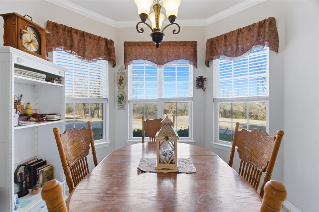 240 Johnson Bend Road Weatherford, TX 76088 - Photo 14 of 40 a view of a dining room with furniture wooden floor and chandelier