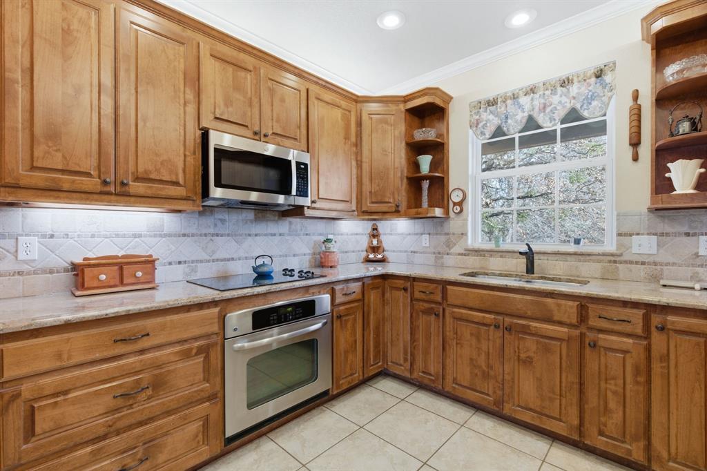 240 Johnson Bend Road Weatherford, TX 76088 - Photo 15 of 40 a kitchen with stainless steel appliances granite countertop a sink a stove and cabinets